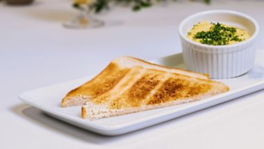 Toasted bread triangles served with scrambled eggs in a ramekin