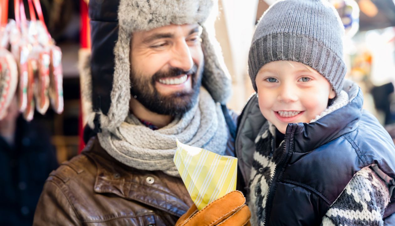 Father and son eating sweet roasted almonds on Christmas Market