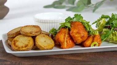 Crispy cauliflower wings with potato wedges and salad