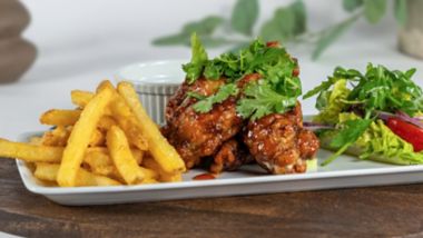 Crispy chicken wings with fries and salad