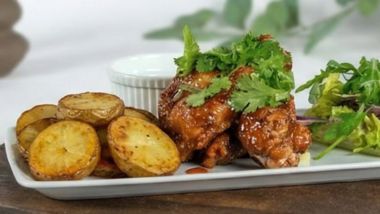 Crispy chicken wings with potato wedges and salad