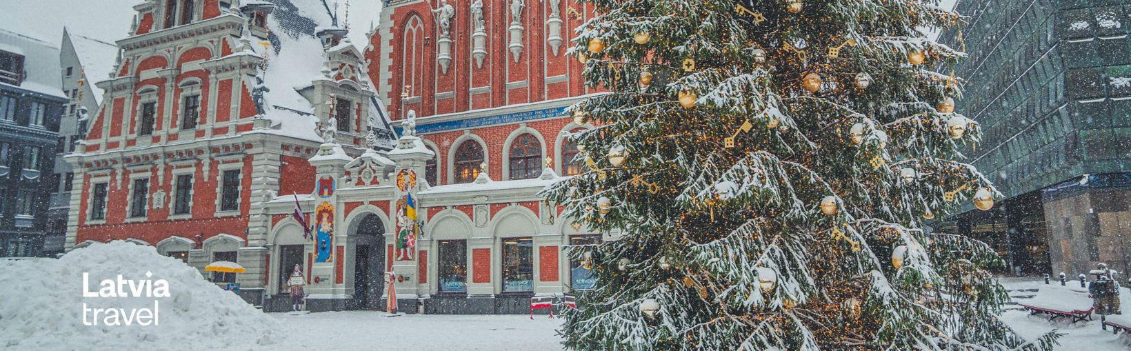 Julgran på snötäckt Rådhustorget i Riga med Svarthuvudenas hus i bakgrunden