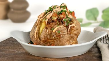 Jacket potato topped with Mexican-style filling and herbs
