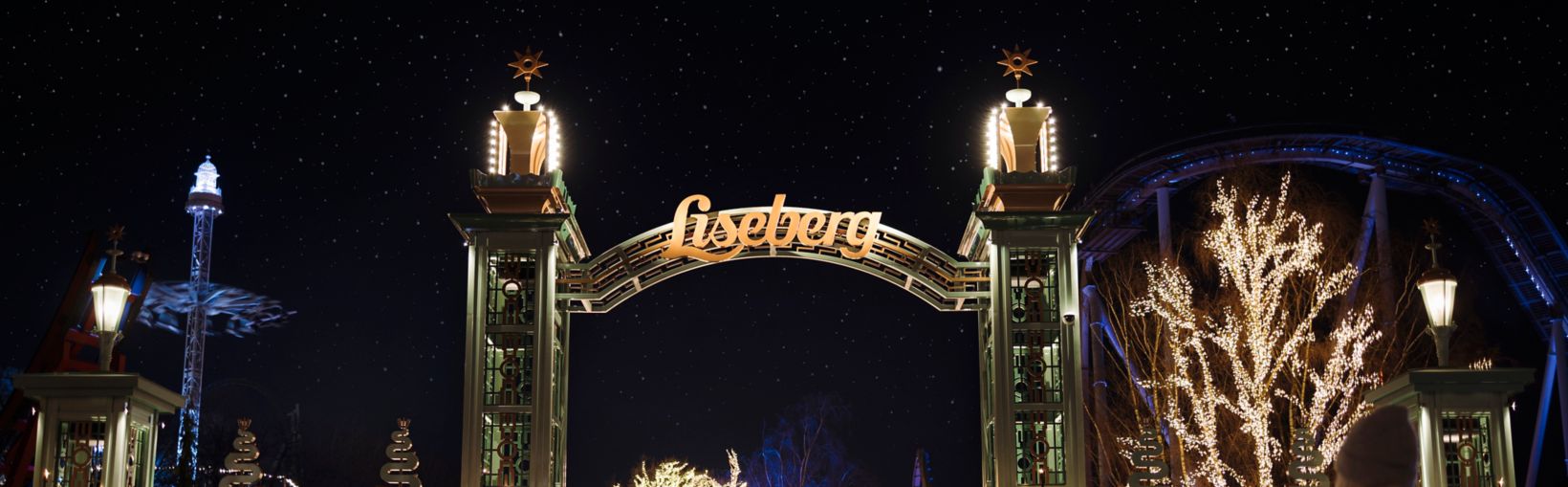 Indgangen til Liseberg i Göteborg oplyst med hyggelige julelys en vinternat. En varm velkomst til besøgende.