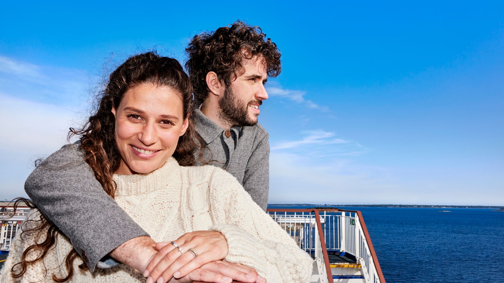 Couple embracing on outer deck of Stena Line ferry, enjoying sea views and fresh air on a relaxing ferry crossing