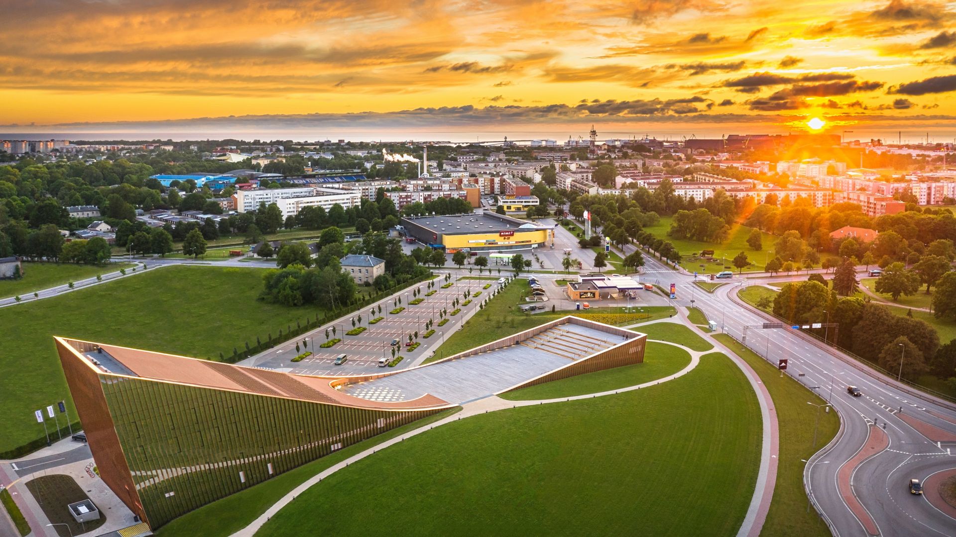 An aeriel view of Ventspils city in northwestern Latvia with the Baltic Sea in the background and the stunning VIZIUM Science Centre building in the foreground.