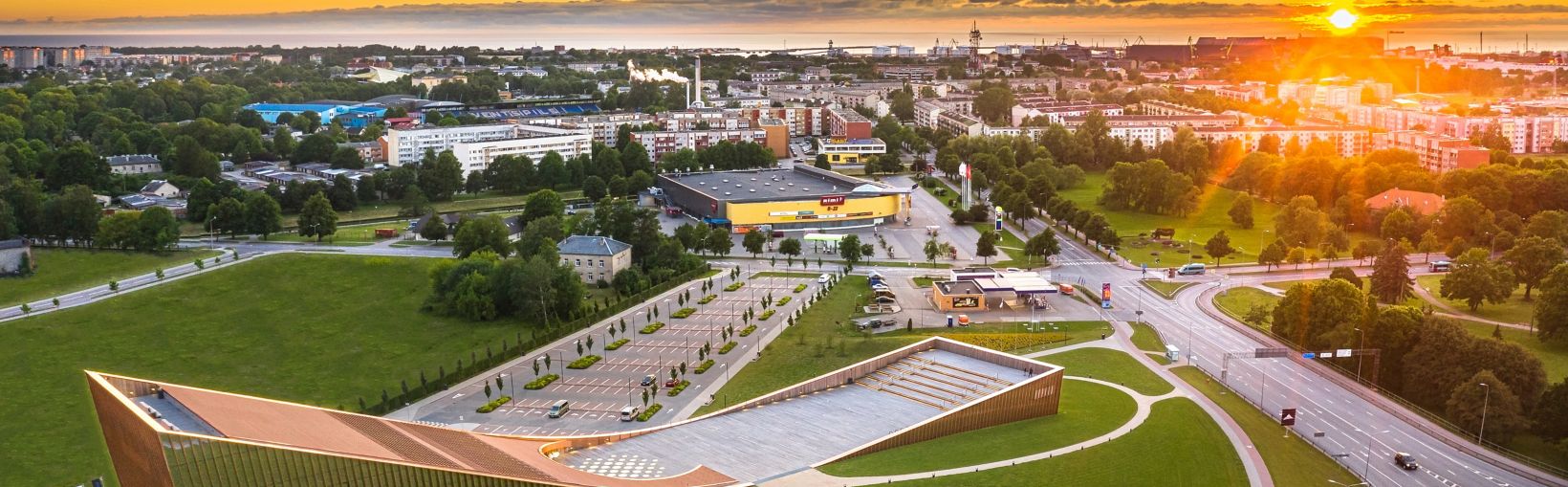 An aeriel view of Ventspils city in northwestern Latvia with the Baltic Sea in the background and the stunning VIZIUM Science Centre building in the foreground.