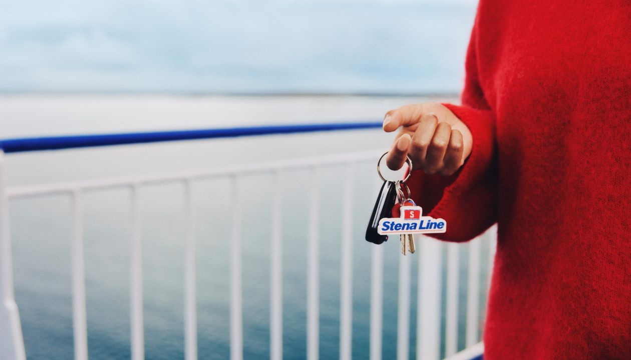 Stambus planas: moteris laiko automobilio raktus su „Stena Line“ raktų pakabuku išorinėje keltų denio dalyje