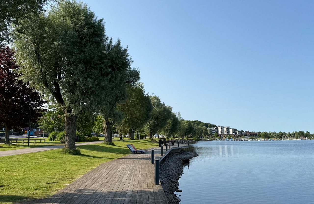 Brygga som löper utmed en sjö med blått vatten