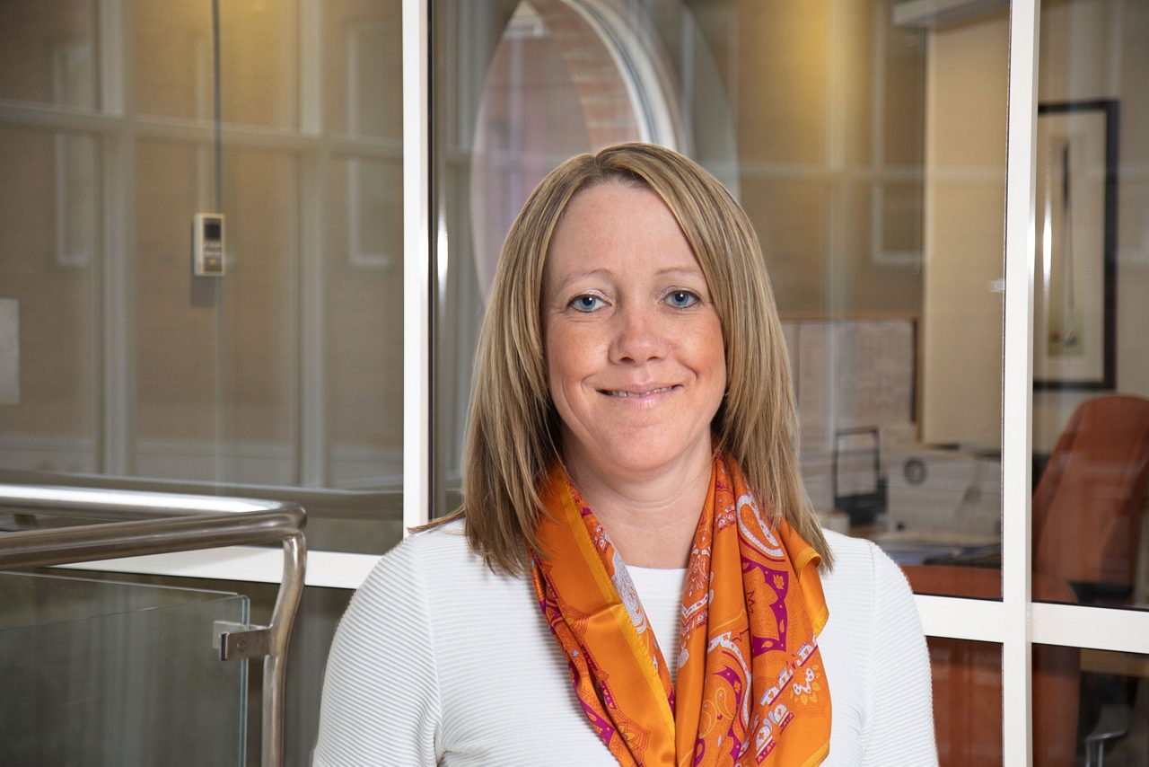 kvinna i vit blus ler mot kameran