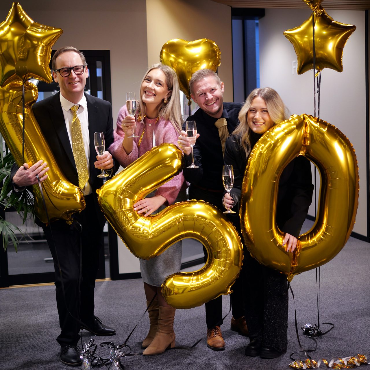 Fyra personer firar och är uppklädda