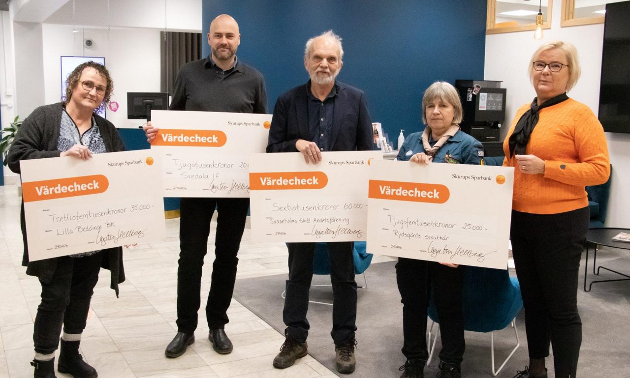 Glada människor med stora checkar