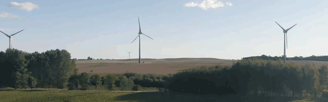 tre vindkraftverk vid horisonten