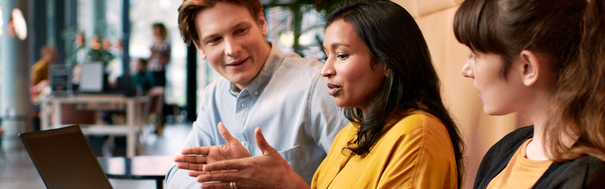 Three persons in a discussion at a work meeting.