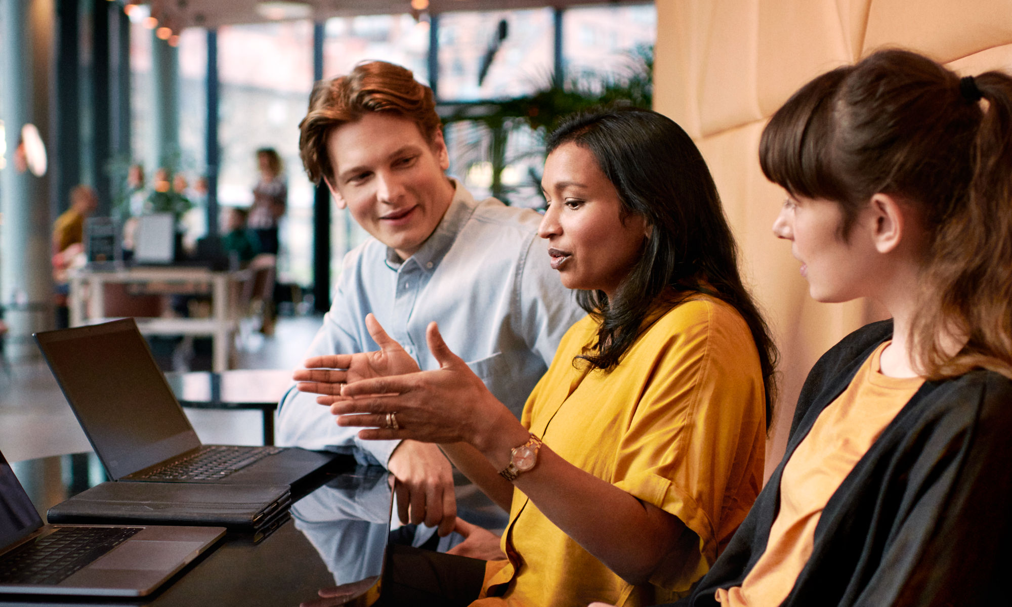 Three persons in a discussion at a work meeting.