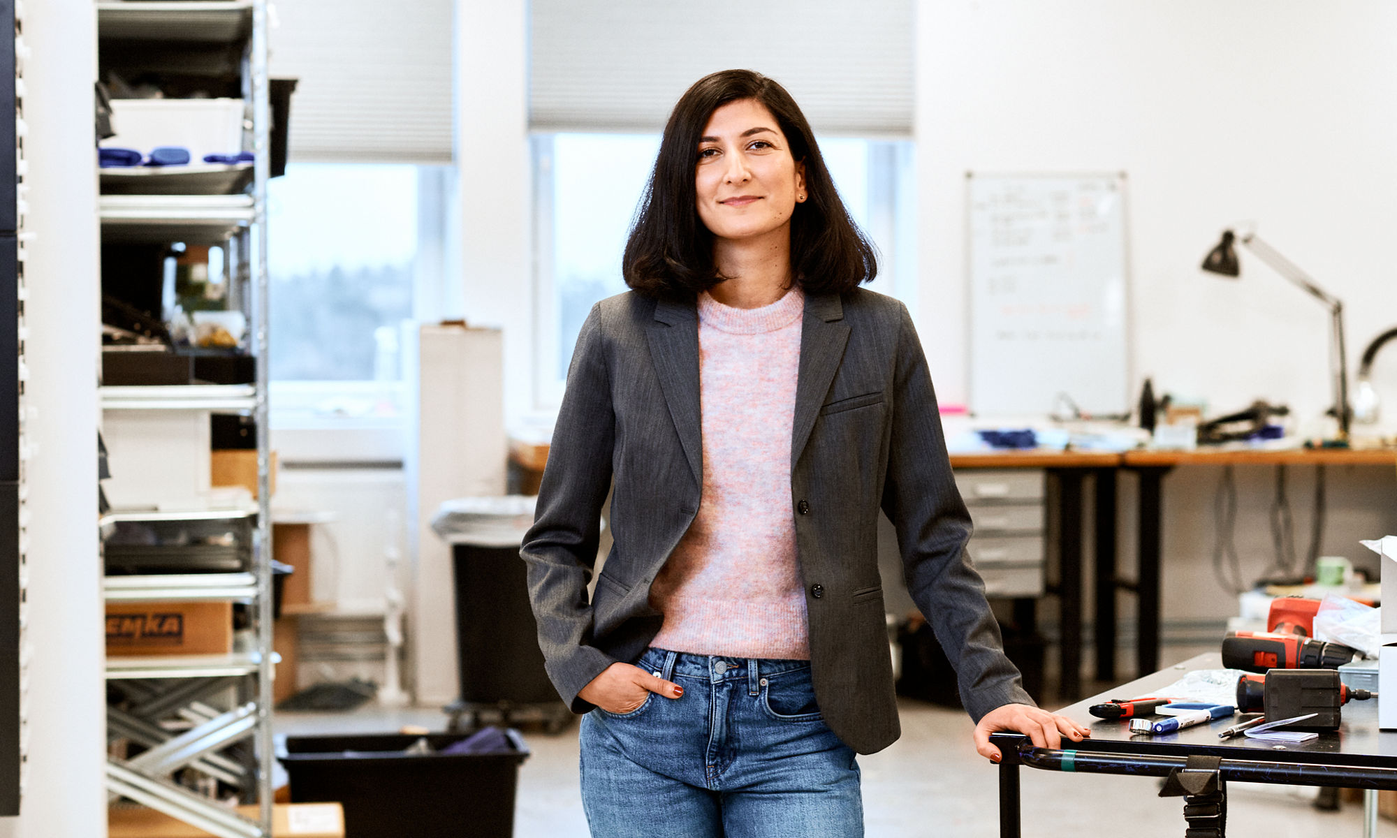 Woman standing at a desk in an office looking into the camera