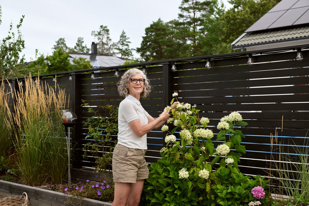  Senior woman working in the garden and looking into the camera.