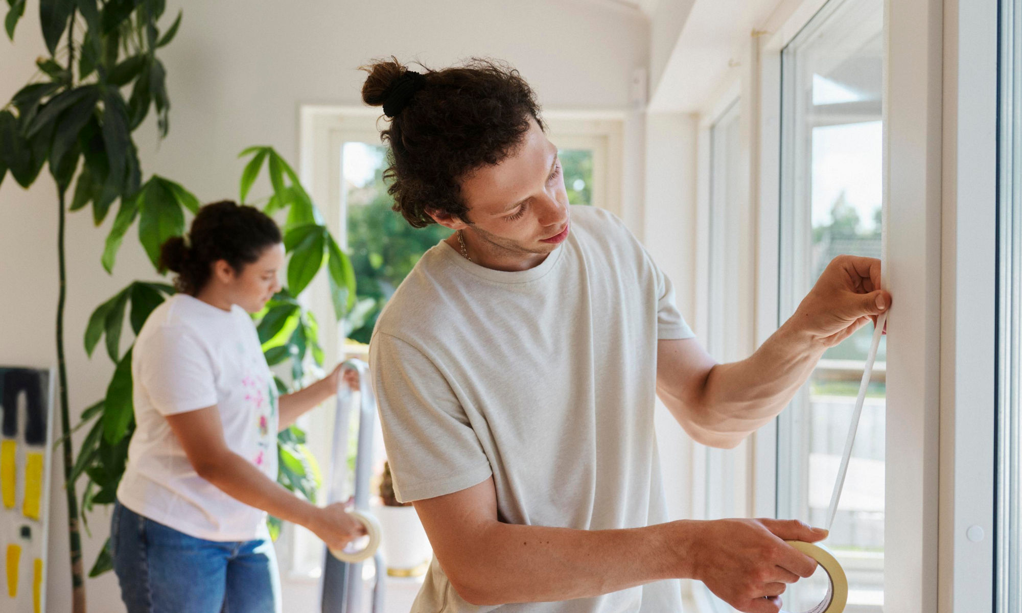 Två unga personer renoverar inne i ett hus