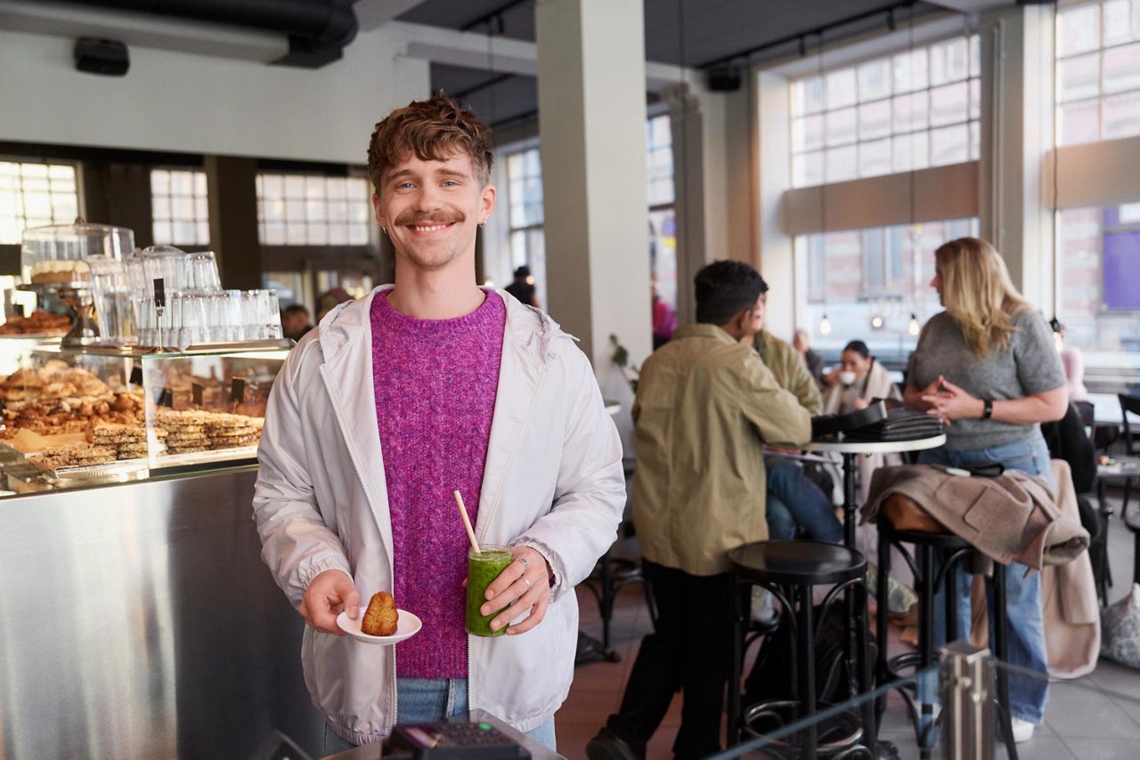 Kille köper fika på ett café