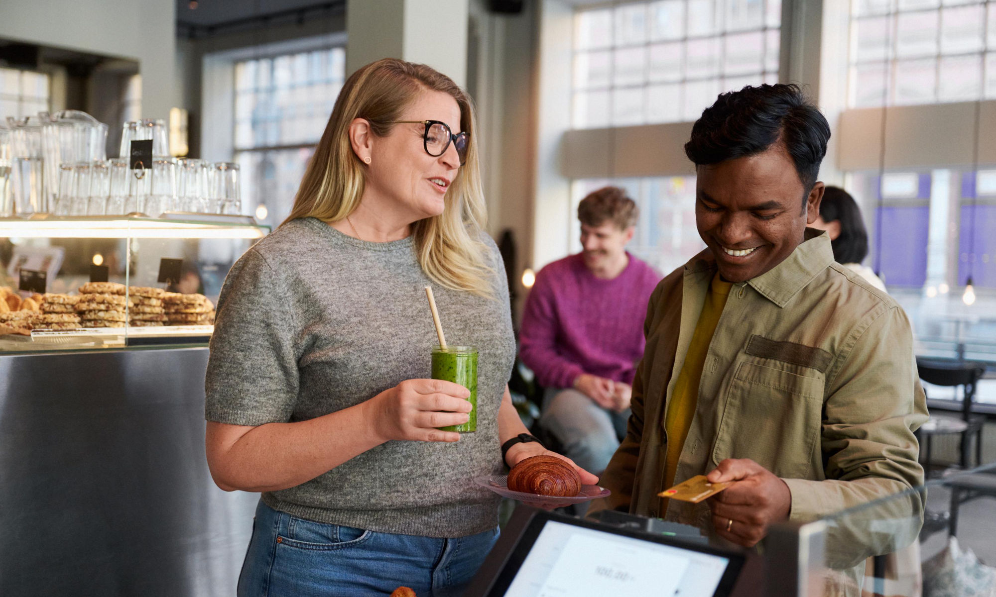 En kvinna och en man köper fika på ett café