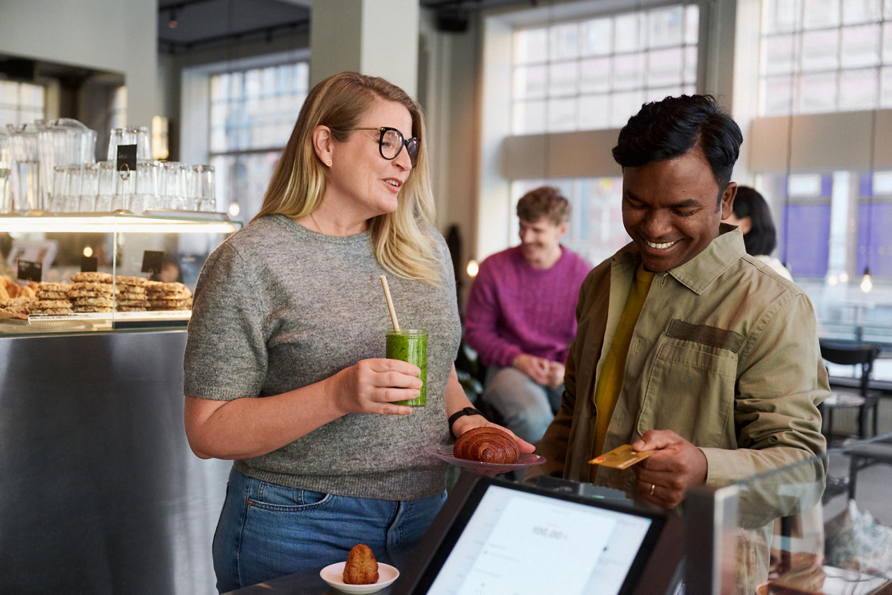 A woman and a man buying coffee at a café