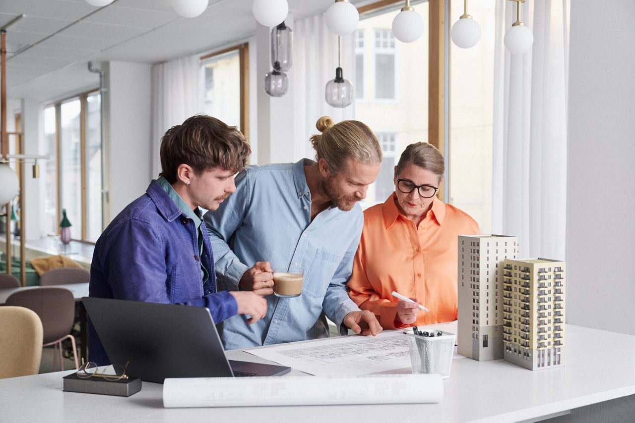 Tre arkitekter planerar en byggnation tillsammans