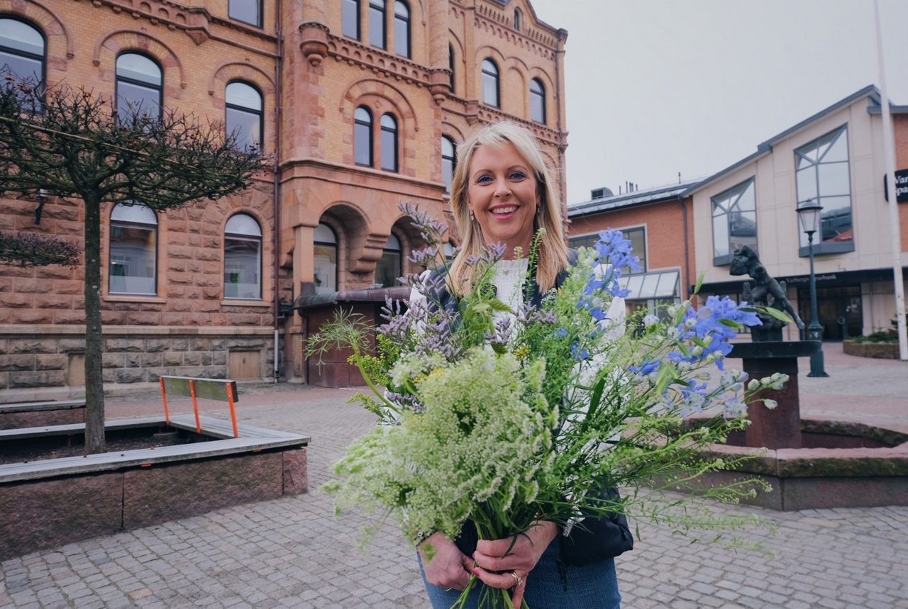 vår lantbruksrådgivare Maria Jahn håller en bukett med ängsblommor i famnen