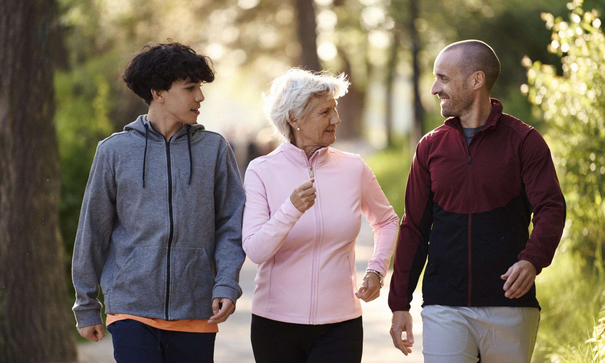 Tre personer i olika åldrar är ute på promenad tillsammans