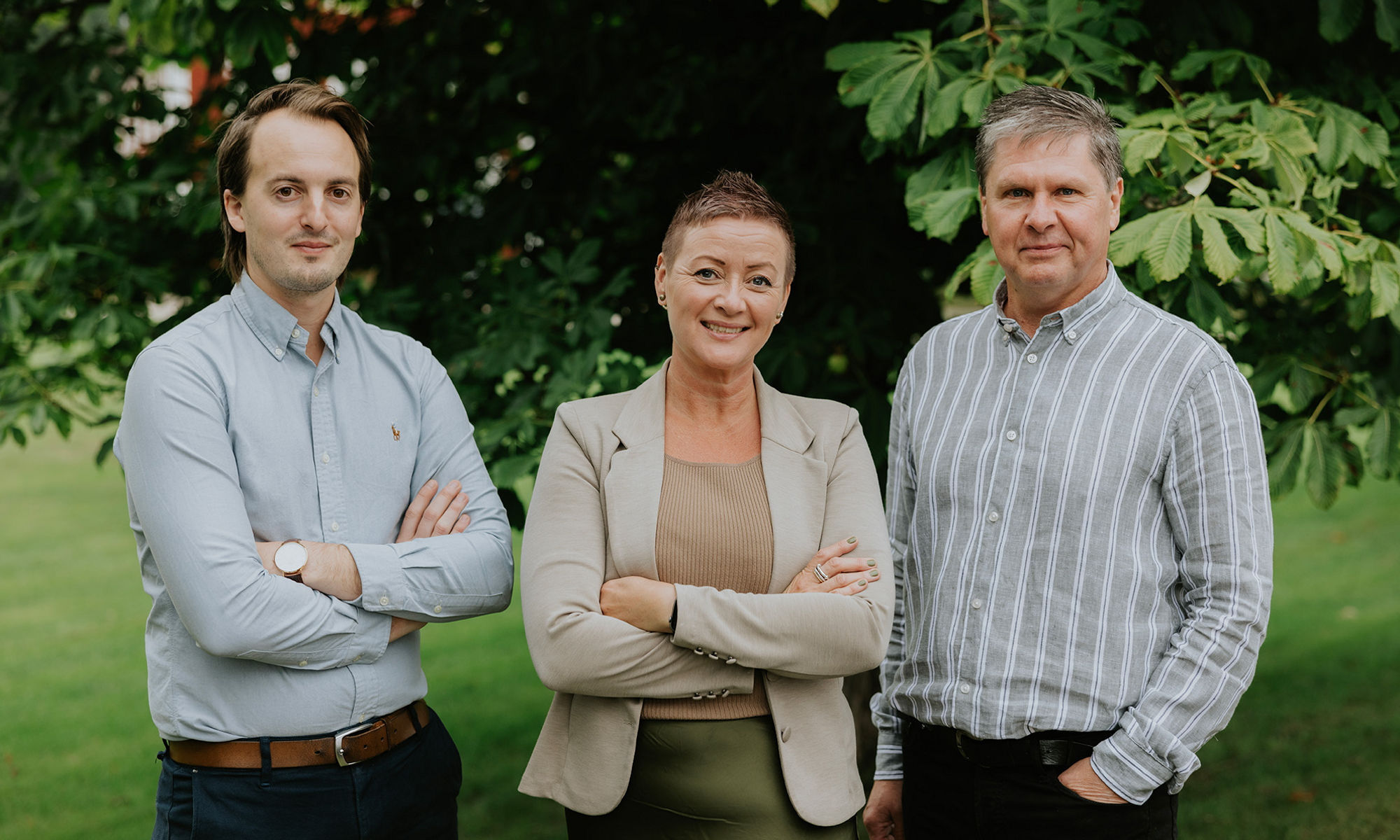 Tre glada medarbetare utomhus