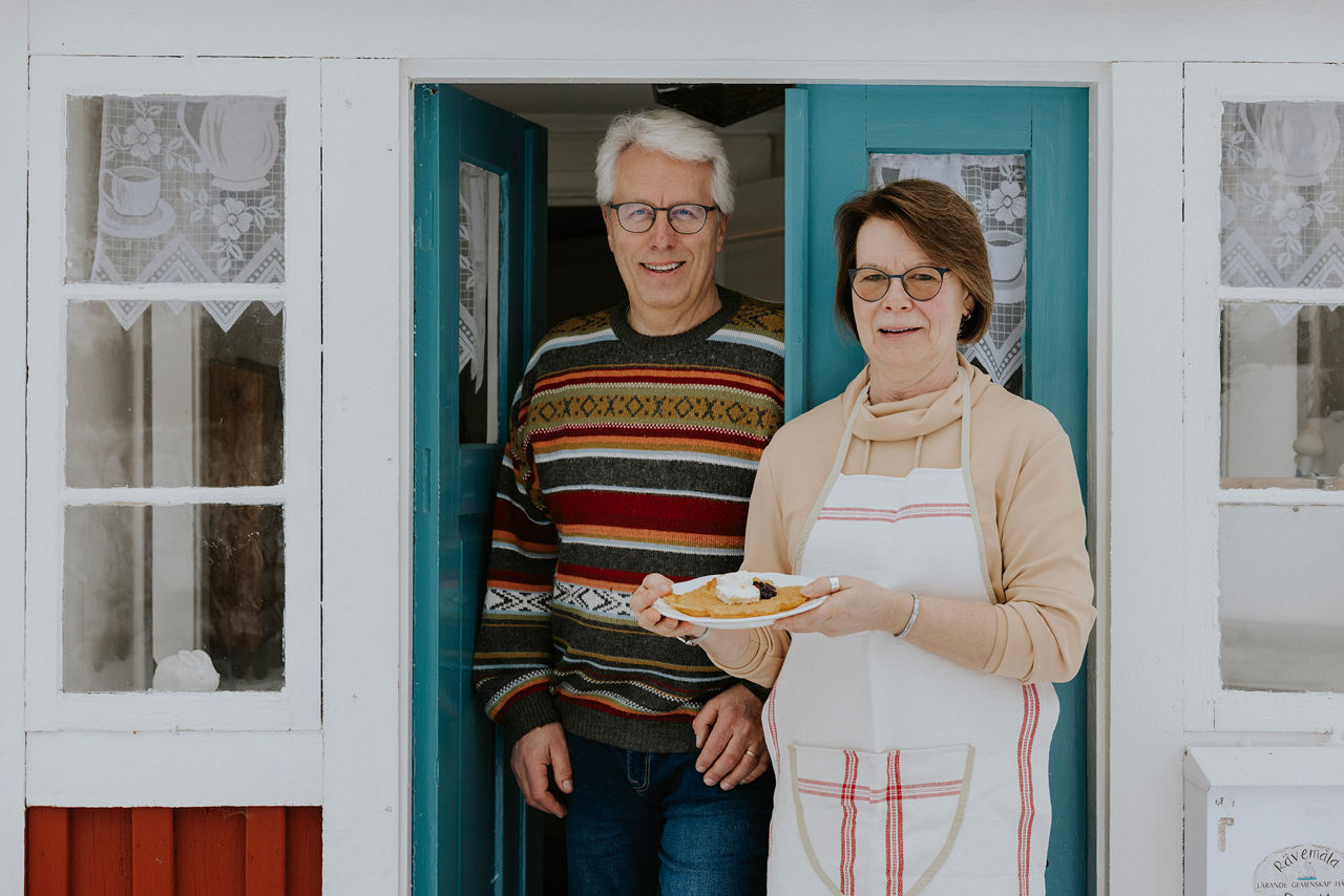 Roger och Lena framför ett litet rött hus