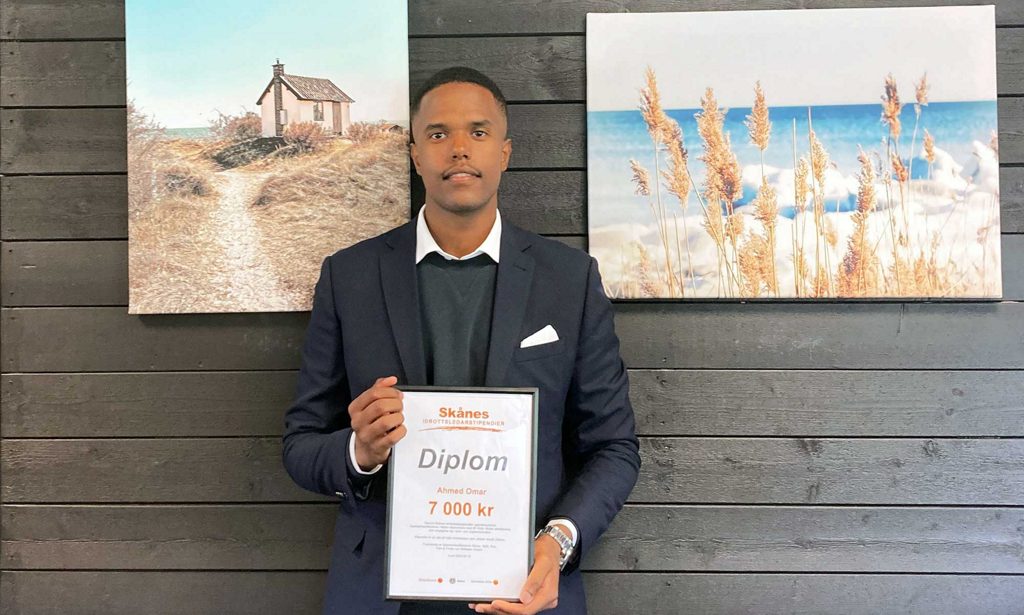 Ahmed Omar håller sitt stipendium Skånes Idrottsledarstipendier i sina händer.
