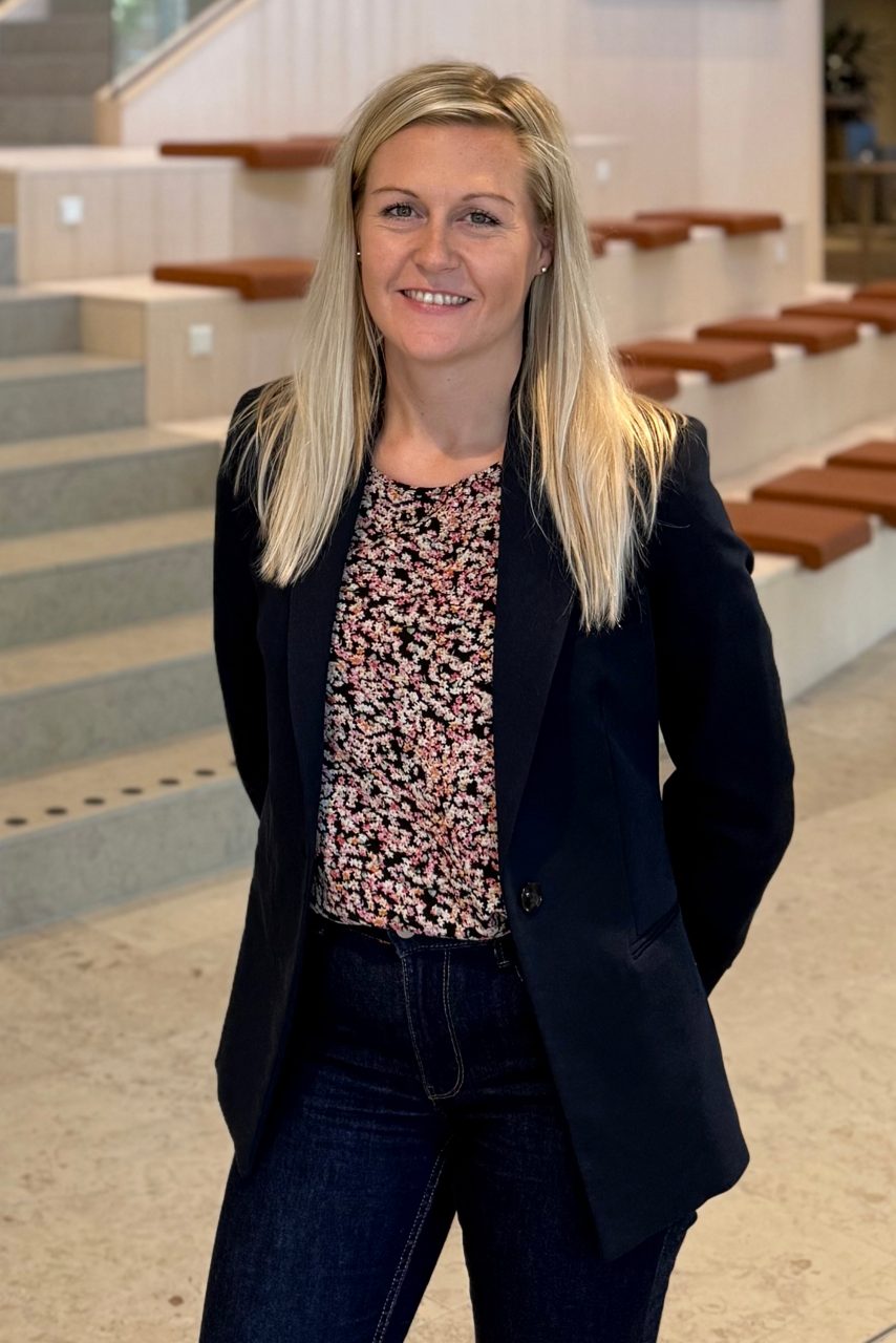 Kvinna tittar in i kameran och ler