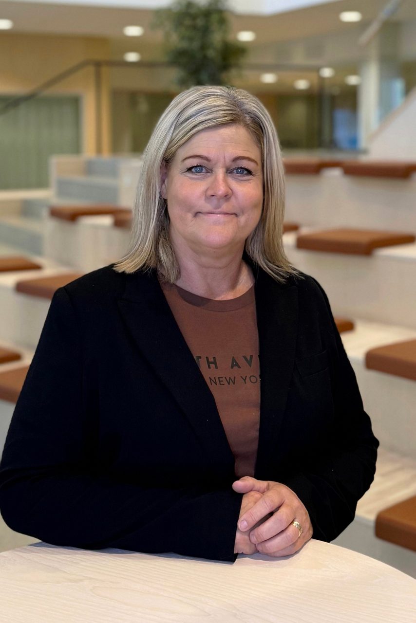 Kvinna tittar in i kameran och ler