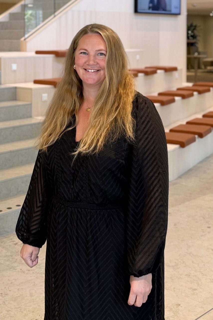 Kvinna tittar in i kameran och ler