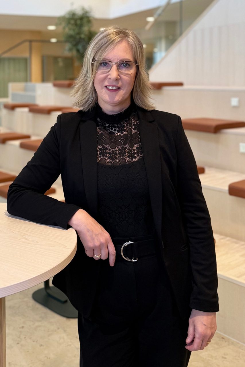 Kvinna tittar in i kameran och ler