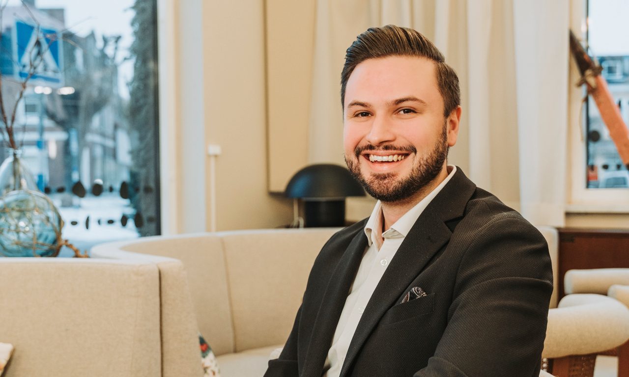 Aron sitter vid sofforna i banksalen