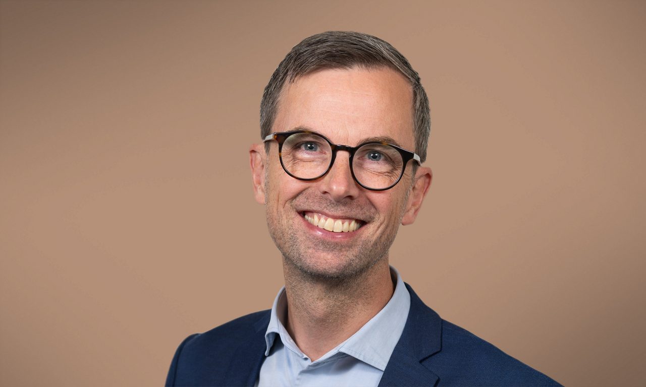 Människor som står och tittar på en brasa utomhus vid en sjö