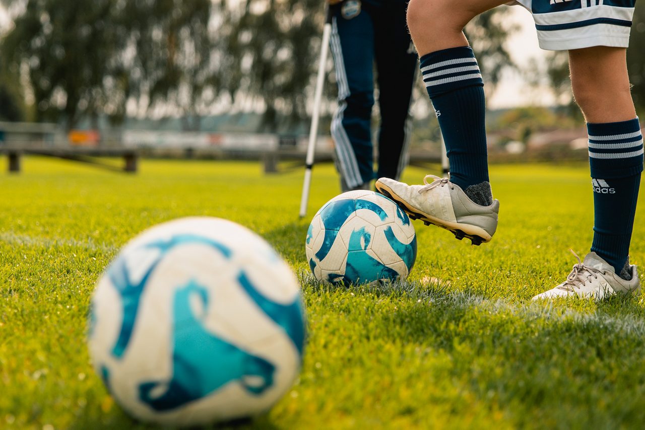 Fotbollsspelares fot på boll