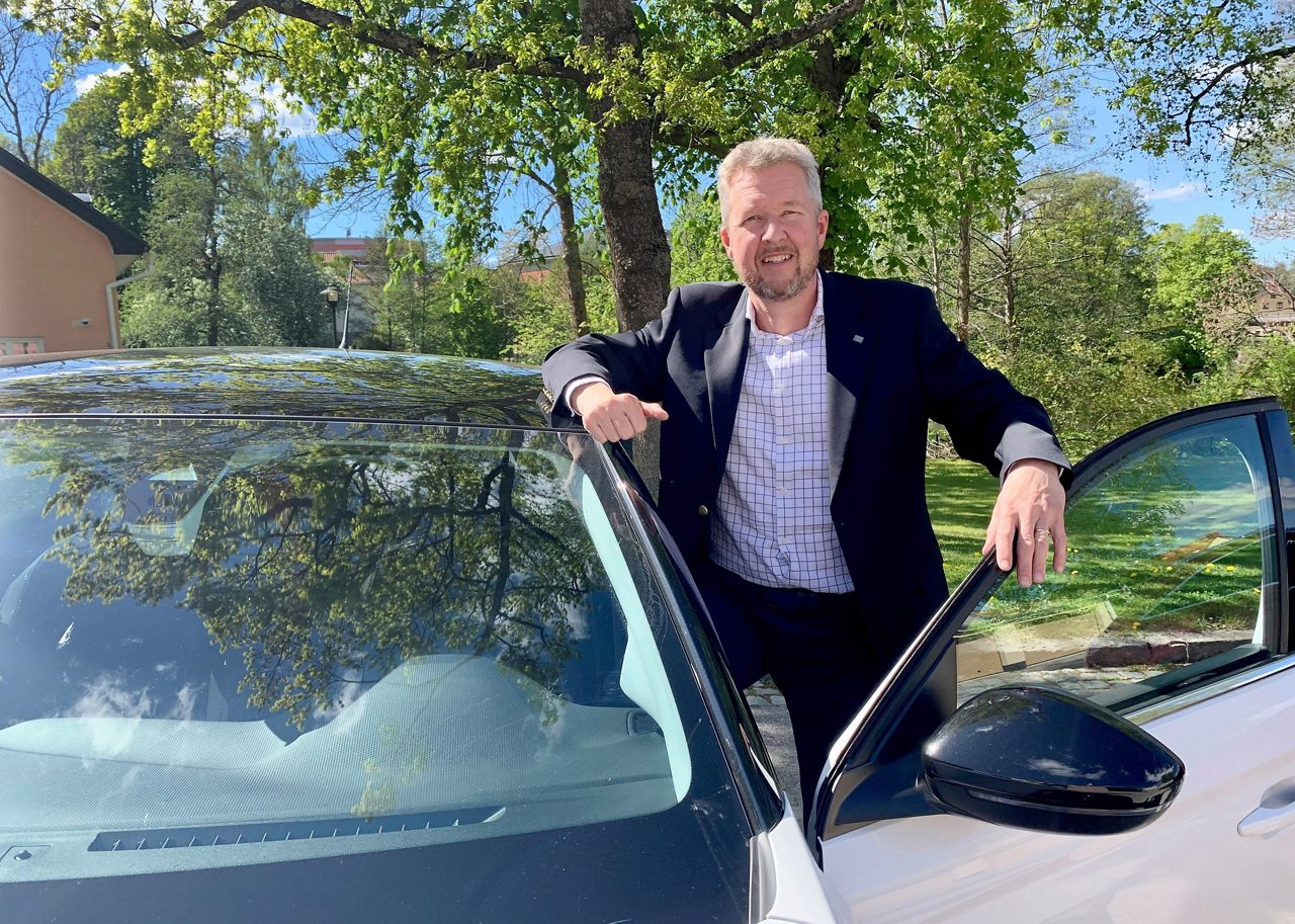 En man står utanför en bil