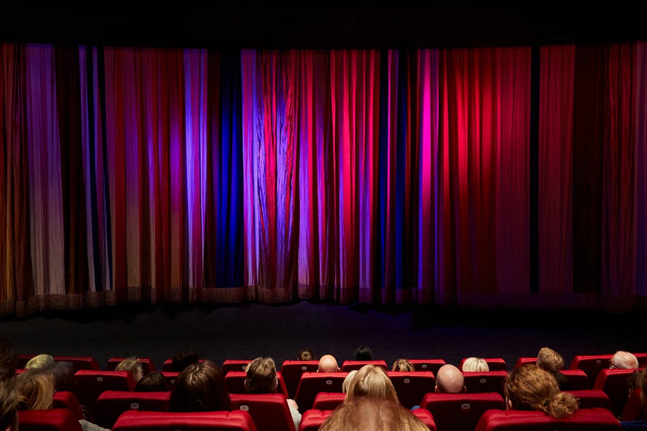 Filmsalong med draperi framför filmduken