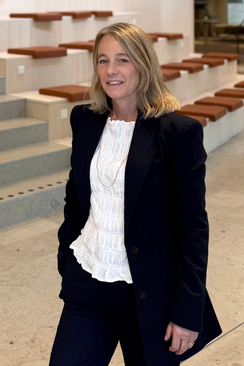 Kvinna tittar in i kameran och ler