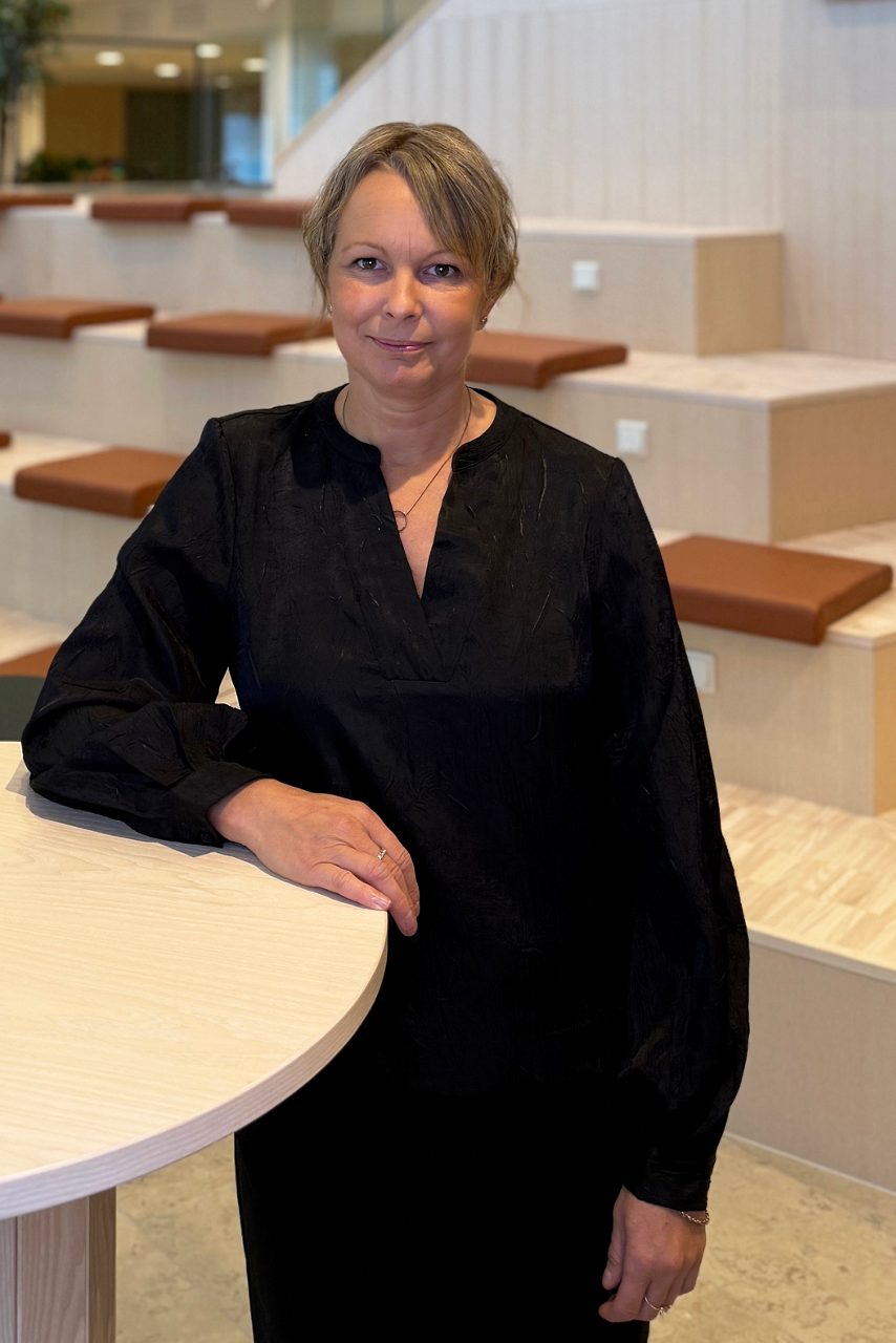 Kvinna tittar in i kameran och ler