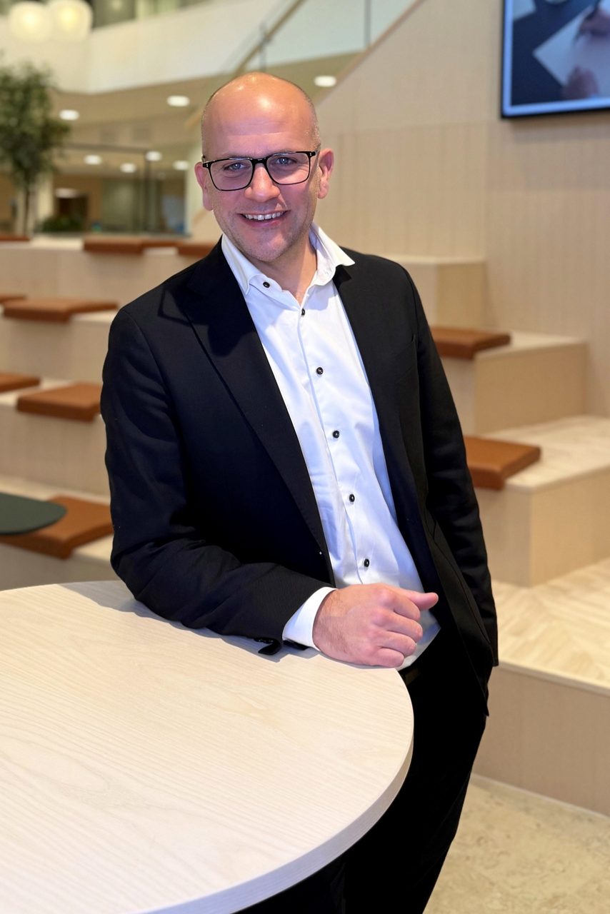 Man tittar in i kameran och ler