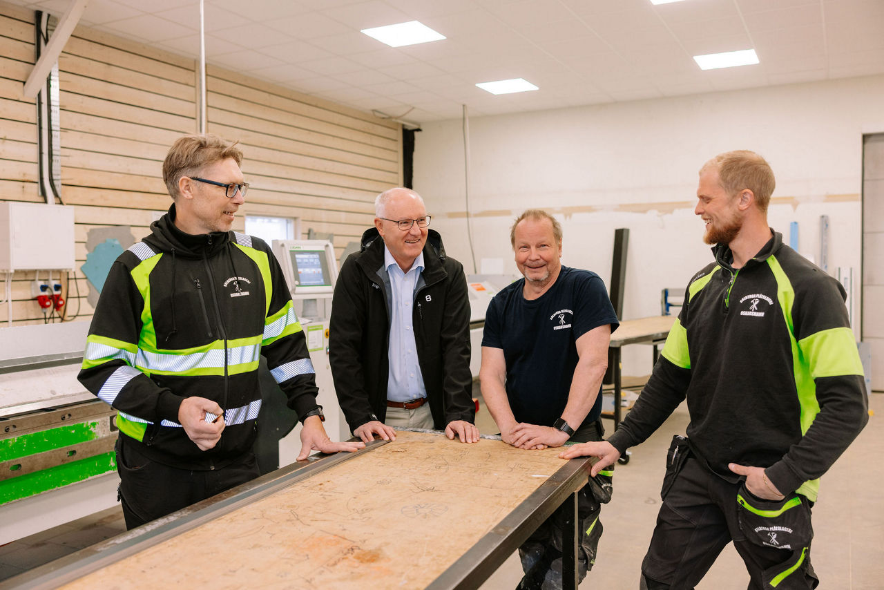 En bild på tre plåtslagare som samtalar med en företagrådgivare på Högsby Sparbank