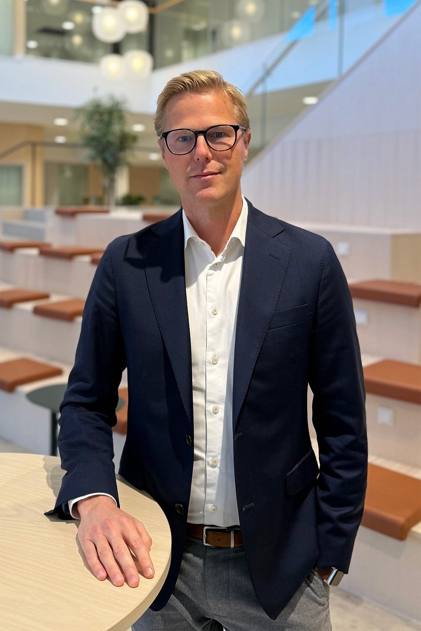 Man tittar in i kameran och ler