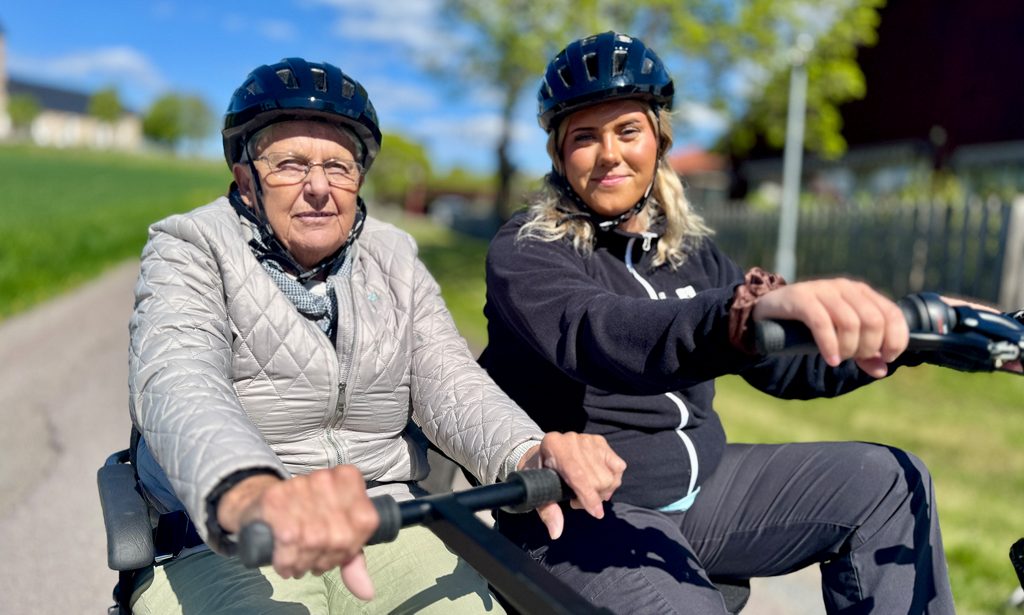 En ur personalen och en boende cyklar på duocykeln.
