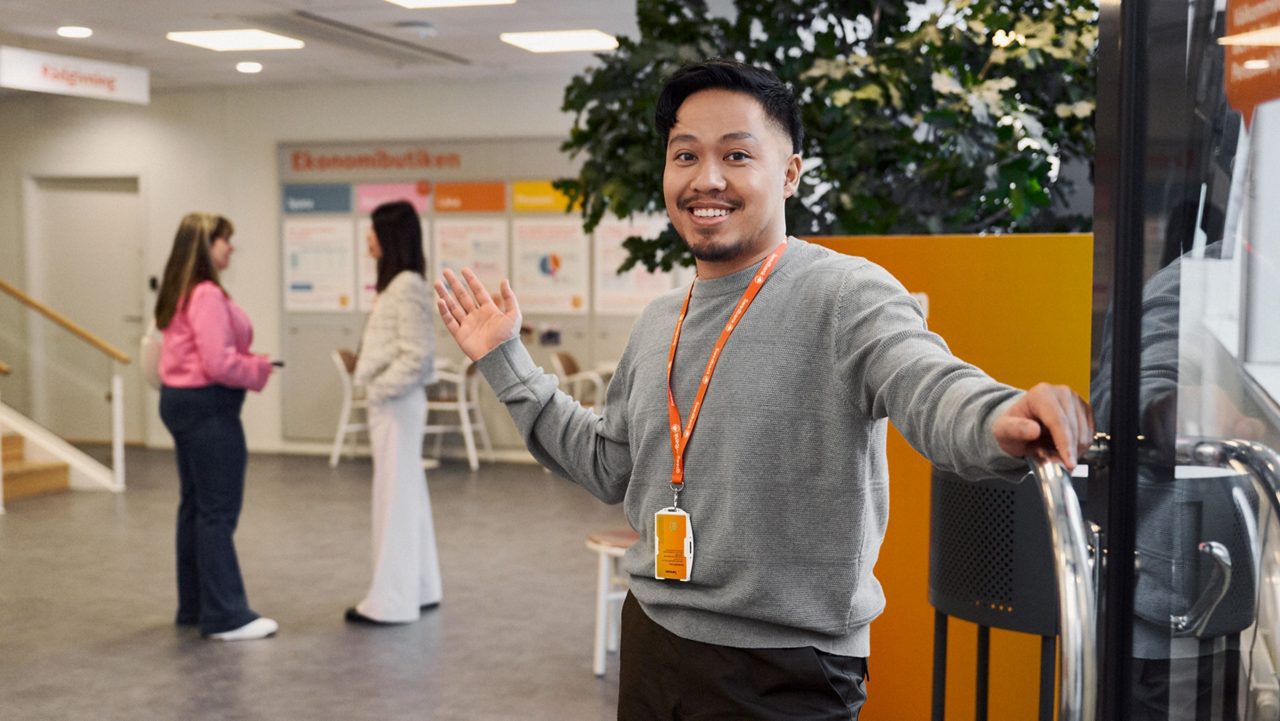 A smiling man stands in an entrance.