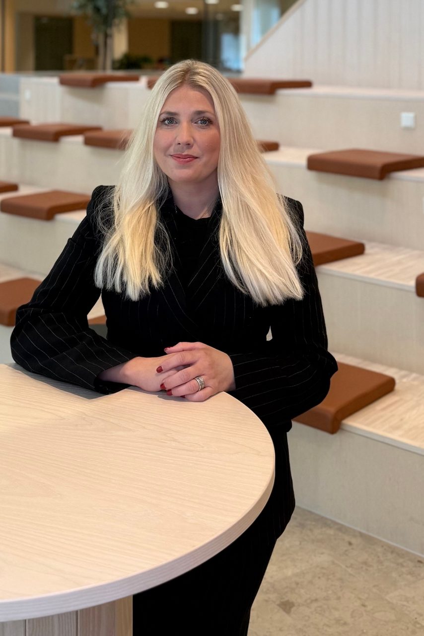 Kvinna tittar in i kameran och ler