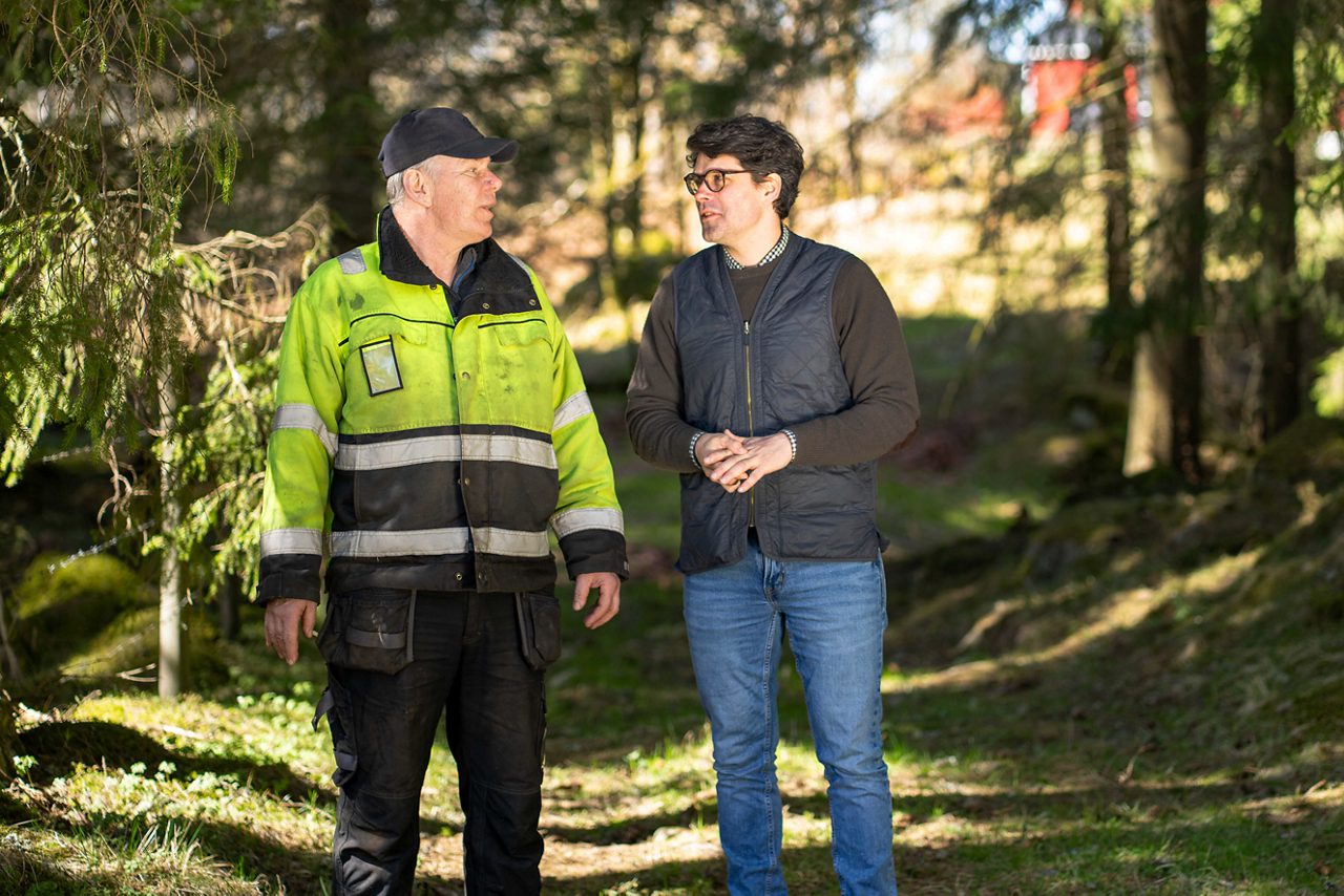 Två män går och pratar i skogen