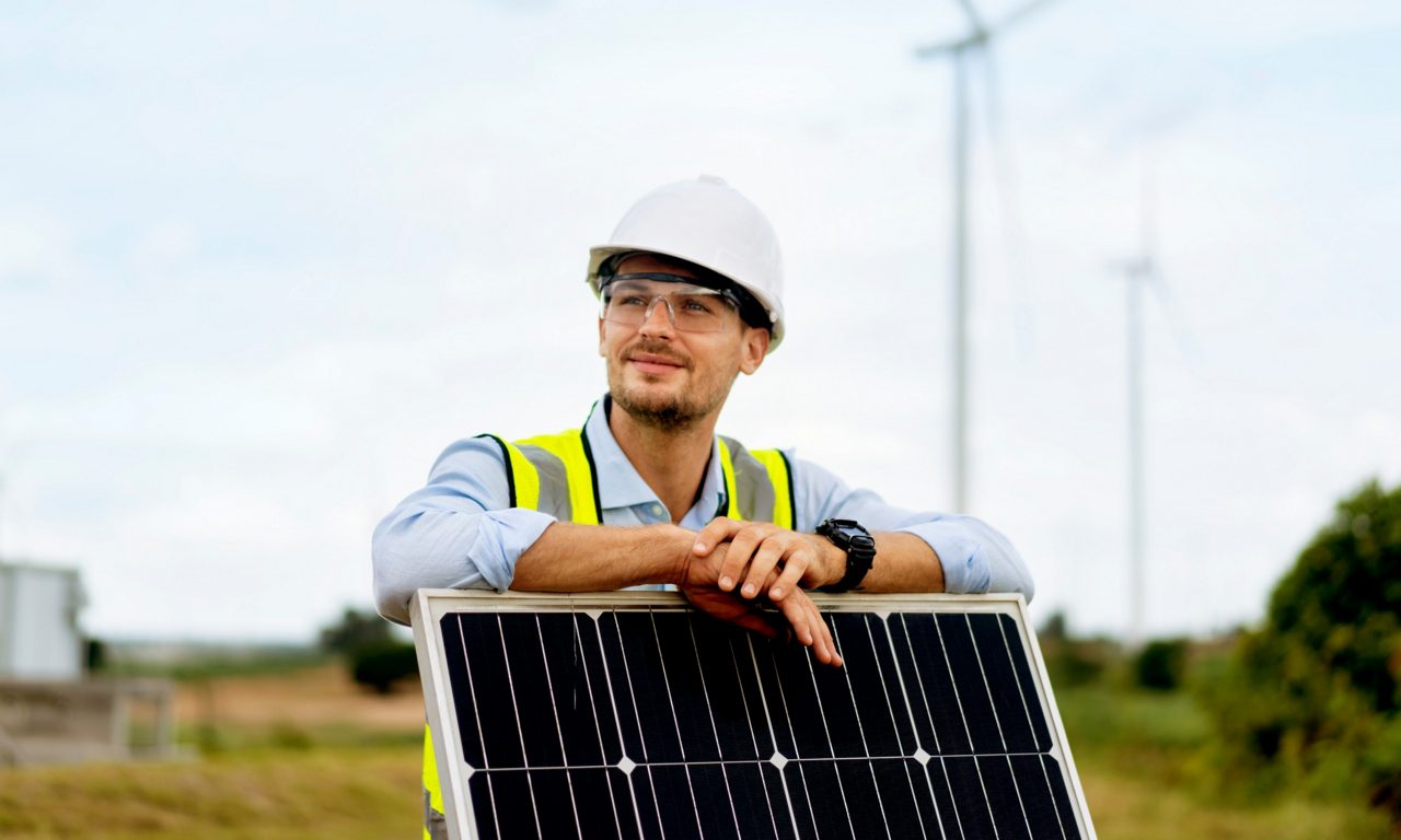 Man lutar sig mot solpanel